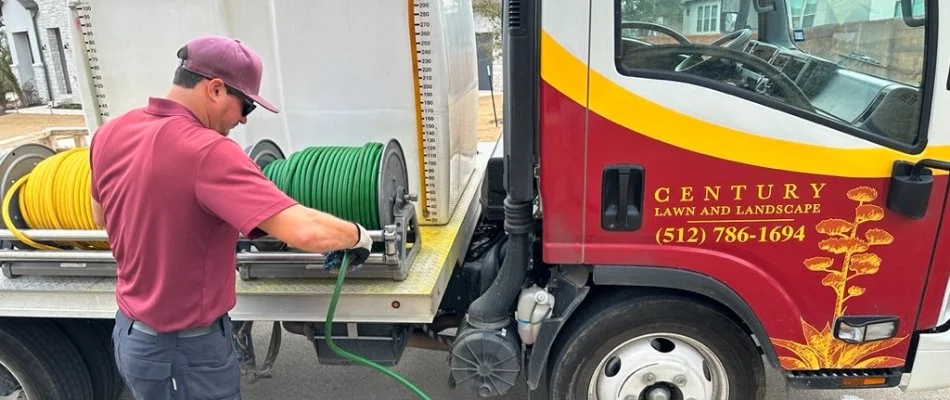 Employee winding up a hose near Austin, TX.