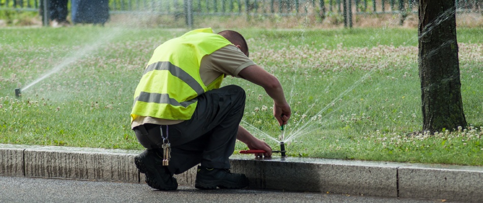 Irrigation tech adjusting sprinkler head in Buda, TX.